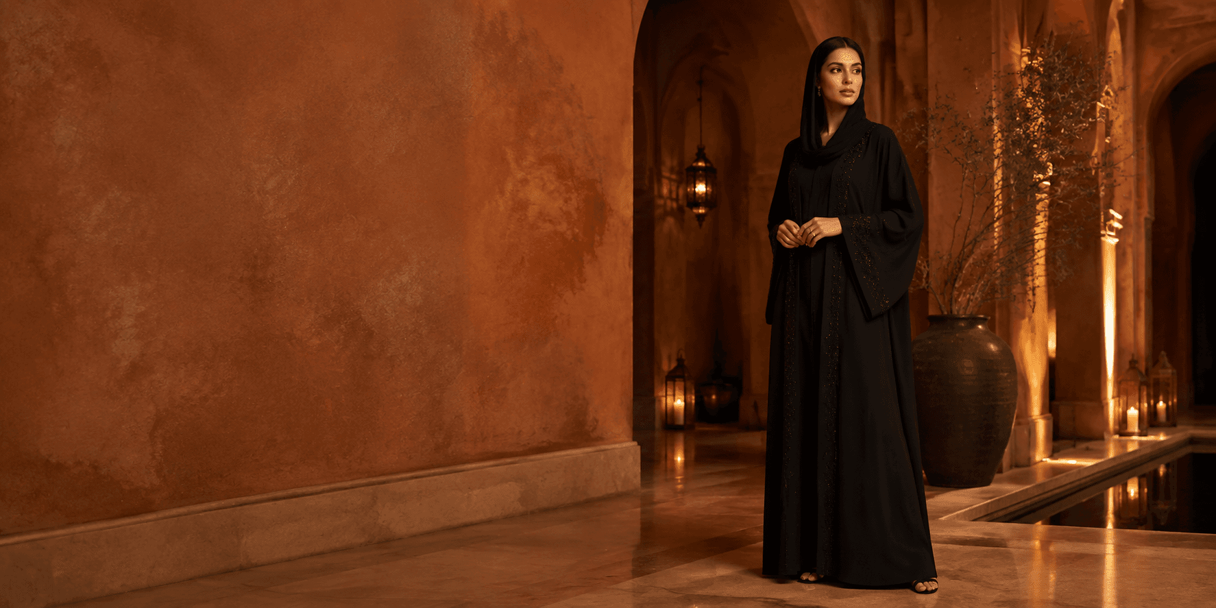 Woman in a black abaya in a warm terracotta interior