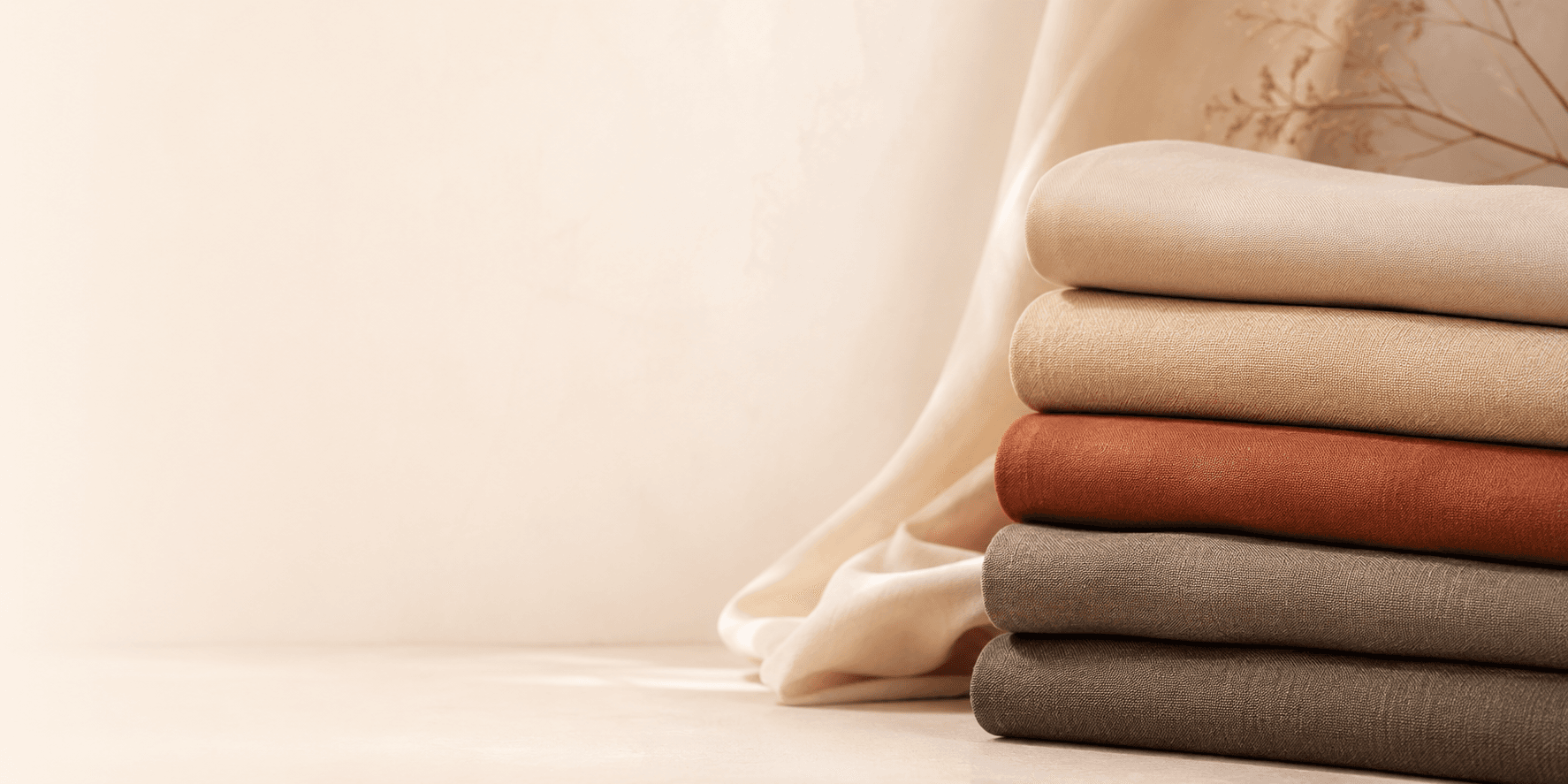 Stack of folded fabrics in warm earth tones