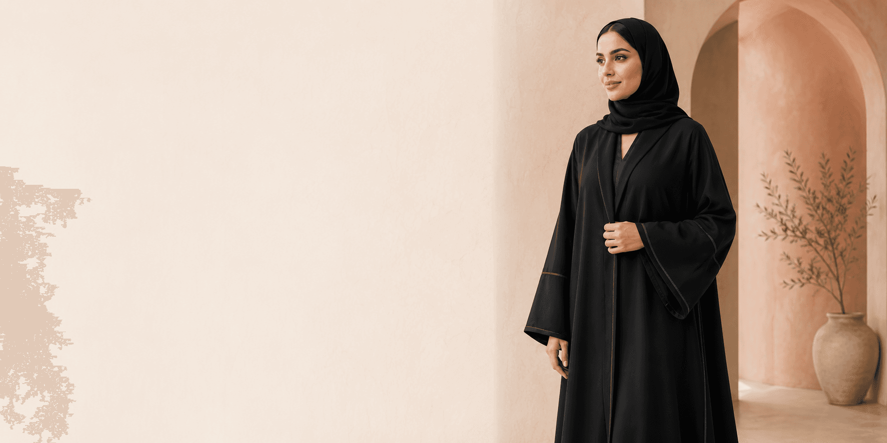 Model wearing a black abaya in a warm terracotta alcove